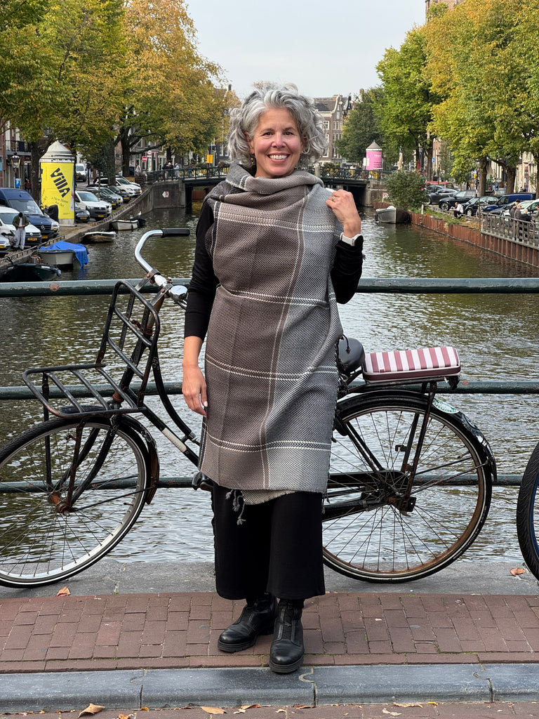 Woman wearing a sepia-toned grey wool plaid cape
