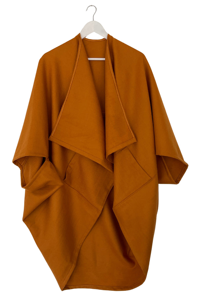Ochre kimono style garment on a white hanger against a white background
