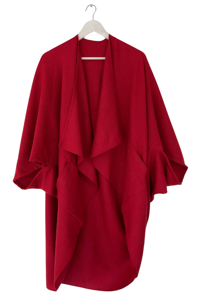 Red kimono-style garment on a hanger against a white background