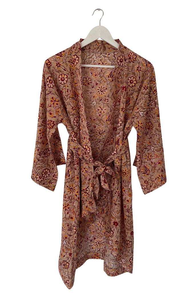 Floral patterned robe on a hanger against a white background