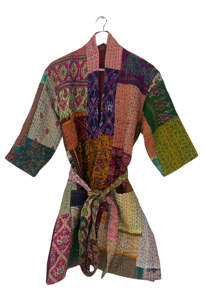 Colorful patchwork jacket on a hanger against a white background