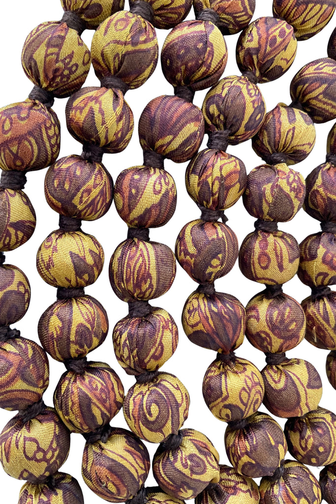 Close up detail of Wooden layered bead necklace covered with silk saris 