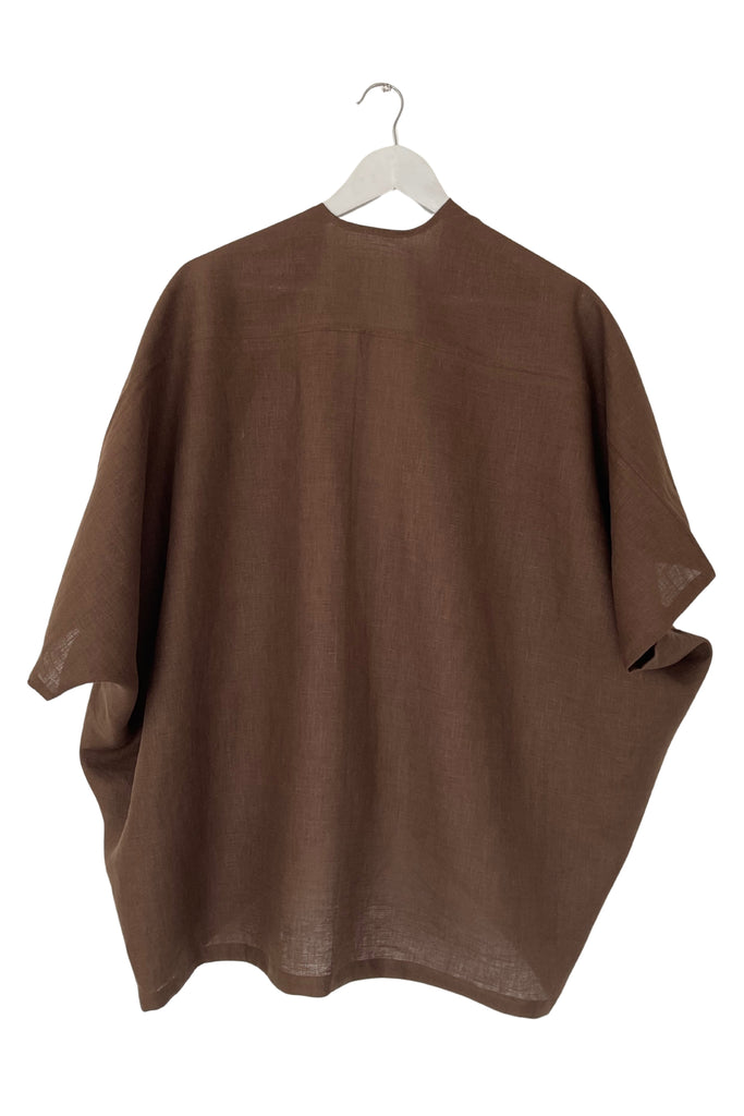 Brown poncho on a hanger against a white background