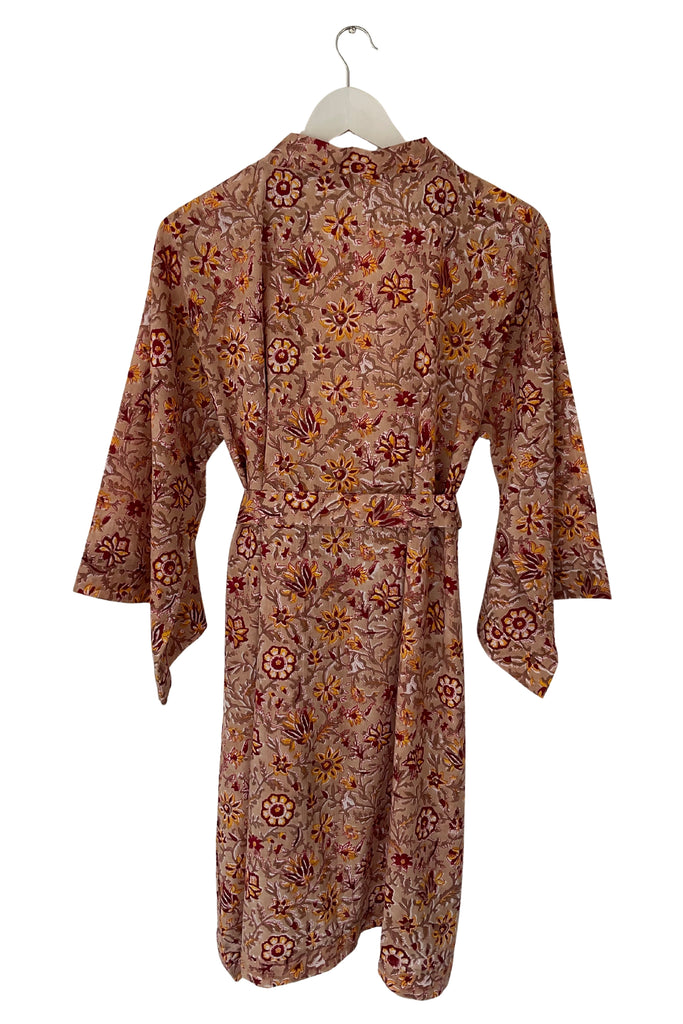 Floral patterned dress on a hanger against a white background