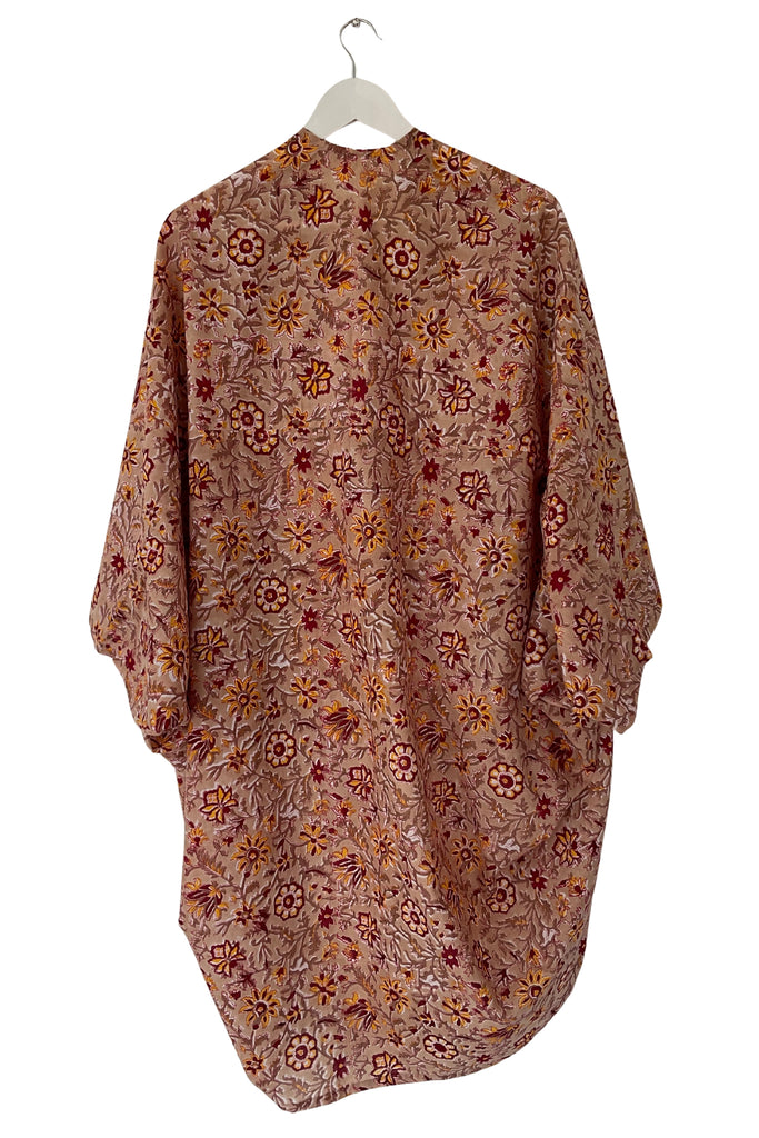 Floral patterned garment on a hanger against a white background