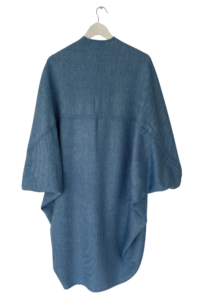 Blue poncho on a hanger against a white background