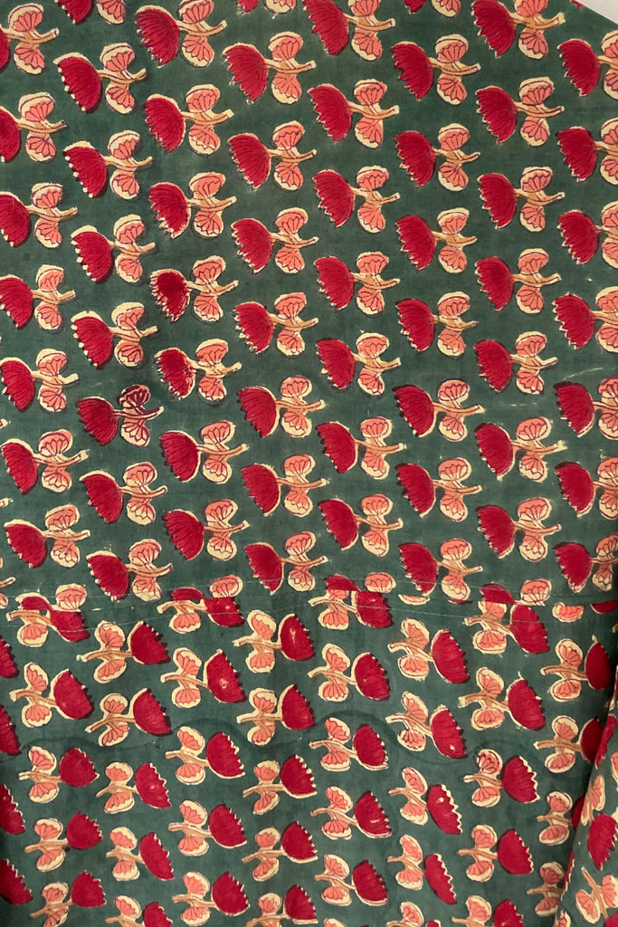 Pattern of red and gold gingerbread men on a green background