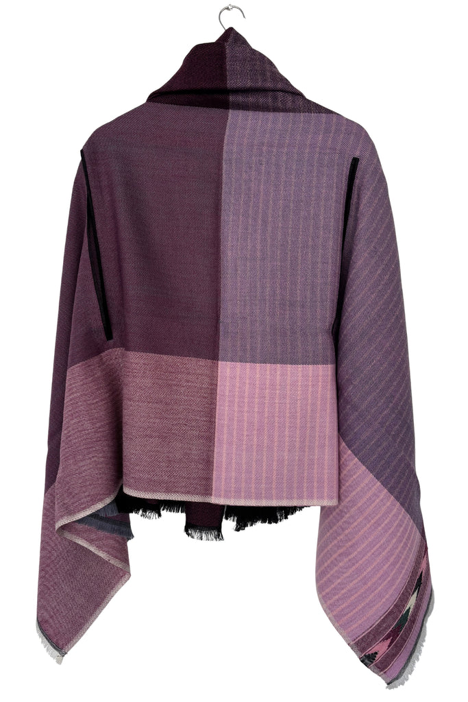 Purple and pink wool Cape on a hanger against a white background