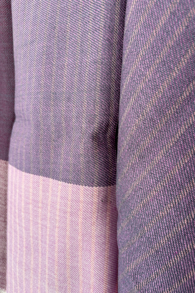Close-up of a purple wool fabric with a subtle woven pattern